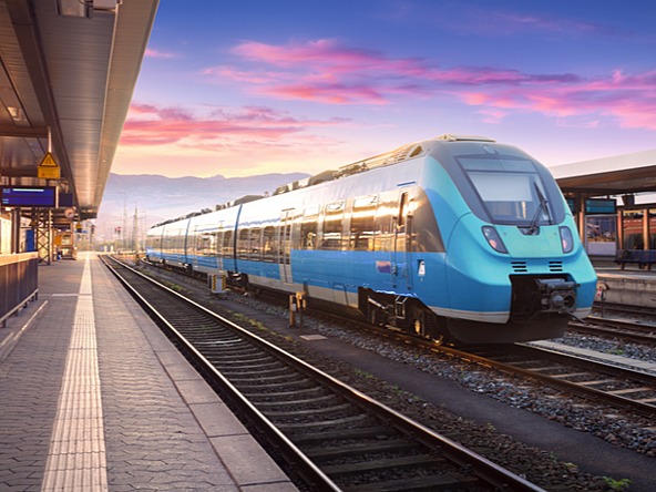 blue train going through station at dusk 